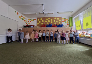 Grupa dzieci śpiewa piosenkę ilustrując ruchem jej trześć