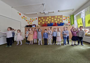 Grupa dzieci śpiewa piosenkę ilustrując ruchem jej trześć