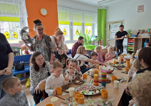 Dzieci wraz z rodzicami spożywają wielkanocne śniadanko