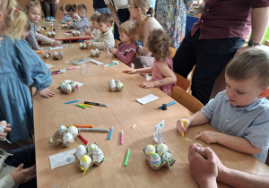 Dzieci wspólnie z rodzicami ozdabiają pisanki