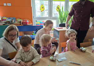 Dzieci wspólnie z rodzicami ozdabiają pisanki