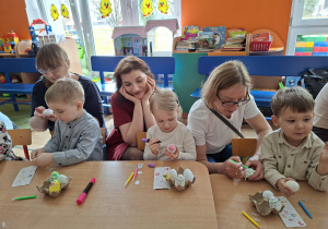 Dzieci wspólnie z rodzicami ozdabiają pisanki