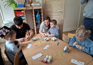 Dzieci wspólnie z rodzicami ozdabiają pisanki