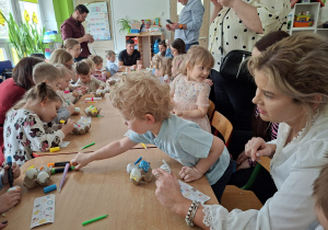 Dzieci wspólnie z rodzicami ozdabiają pisanki