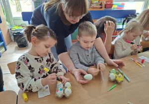 Dzieci wspólnie z rodzicami ozdabiają pisanki