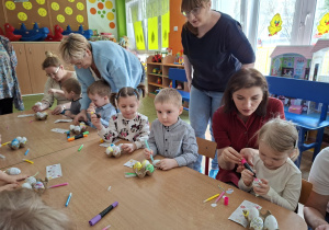 Dzieci wspólnie z rodzicami ozdabiają pisanki