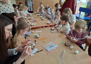 Dzieci wspólnie z rodzicami ozdabiają pisanki