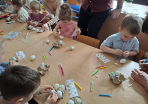 Dzieci wspólnie z rodzicami ozdabiają pisanki