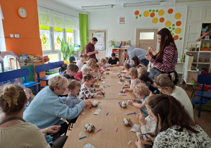 Dzieci wspólnie z rodzicami ozdabiają pisanki