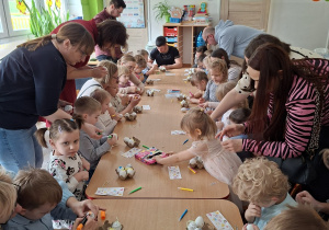 Dzieci wspólnie z rodzicami ozdabiają pisanki