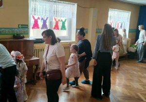 Dzieci wraz z rodzicami szukają na holu schowanych jajek