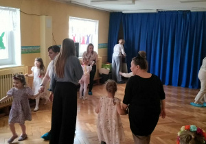 Dzieci wraz z rodzicami szukają na holu schowanych jajek