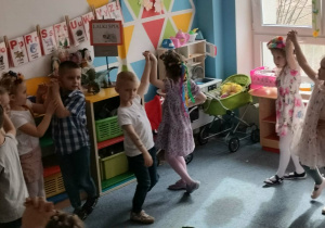 Grupa dzieci tańczy na dywanie