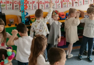 Grupa dzieci tańczy na dywanie