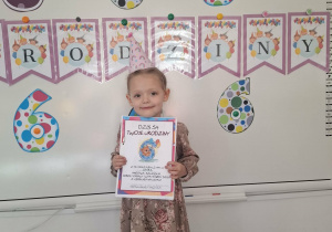 Laura pozuje do zdjęcia z urodzinowym dyplomem