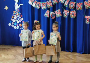 Troje dzieci z dyplomami i upominkami