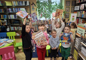 Grupa dzieci ogląda książki w kąciku czytelniczym