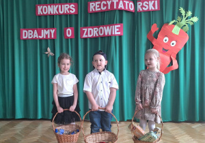 Dzieci stoją na środku sali i recytuą wiersz
