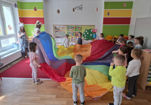 Dzieci biorą udział w zabawie z chustą animacyjną