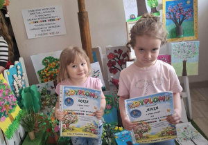 Dzieci pozują do zdjęcia pokazując swoje dyplomy za udział w konkursie