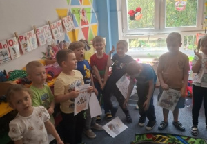 Dzieci stoją na dywanie i śpiewają Sarze sto lat