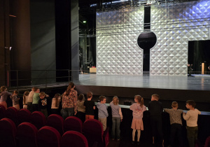 Dzieci na widowni słuchają ciekawostek o teatrze