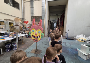 Dzieci zwiedzają salę, w której powstają dekoracje teatralne