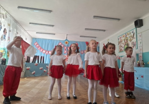 Dzieci stoją na środku sali i śpiewają piosenkę