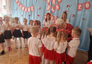 Dzieci stoją na środku sali i odbierają dyplomy i nagrody
