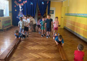 Dzieci przeciągają się po ławeczce