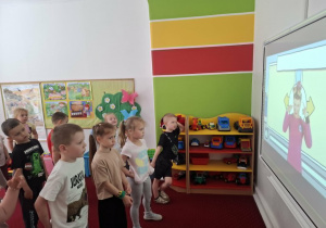Dzieci ćwiczą wg wskazuwek pokazanych na tablicy multimedialnej