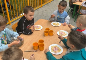 Dzieci jedzą obiad na tarasie przedszkolnym