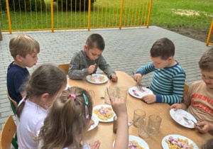 Dzieci jedzą obiad na tarasie przedszkolnym