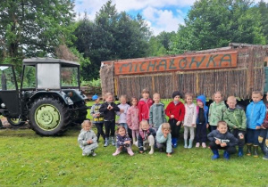 Dzieci przed przyczepą z napisem Michałówka