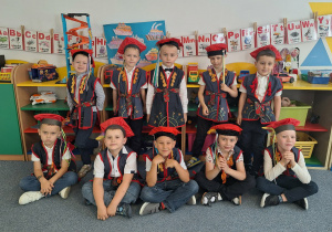 Grupa chłopców stoi i pozuje do zdjęcia w strojach krakowskich