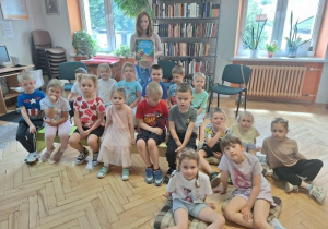 Dzieci siedzą i pozują do zdjęcia z p.bibliotekarką