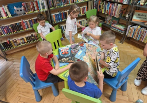 Grupa dzieci ogląda książki w kąciku czytelniczym