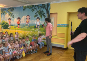 Muzyk z obojem i muzyk z mikrofonem oraz grupa dzieci