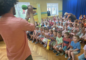 Muzyk z mikrofonem i grupa dzieci