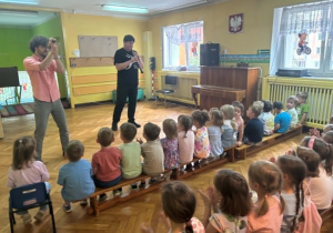 Muzyk z obojem i muzyk z mikrofonem oraz grupa dzieci