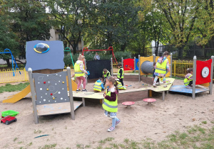 Grupa dzieci bawi się w parku na placu zabaw