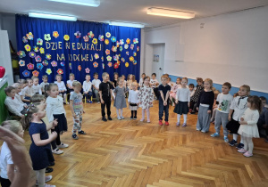 Dzieci ustawione w półkole recytują wiersz