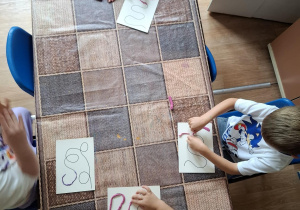 Dzieci wylepiają plasteliną po śladzie