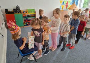 Dziewczynka częstuje dzieci cukierkami