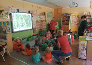 Dzieci oglądają prezentację multimedialną o ogórkach i marchewkach