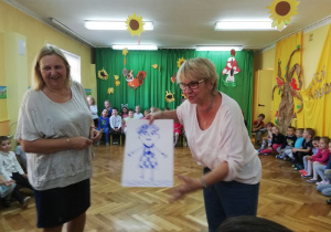 Nauczycielka prezentuje personelowi narysowaną przez siebie postać