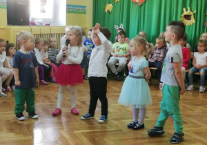 Pięcioro dzieci mówi wiersz na środku sali