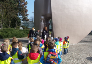 Dzieci stoją pod pomnikiem
