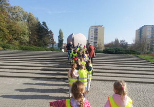 Dzieci wchodzą po schodach prowadzących do pomnika