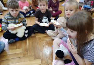 Szóstka dzieci zjada miód z talerzyków